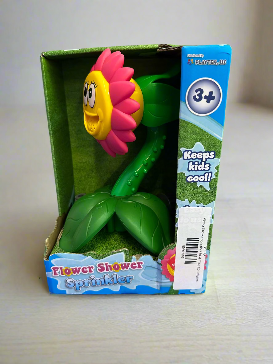 Flower-shaped sprinkler toy in packaging on a purple surface