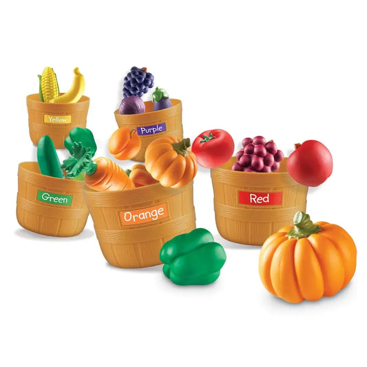 Color-coded toy fruit and vegetable set with baskets on a white background