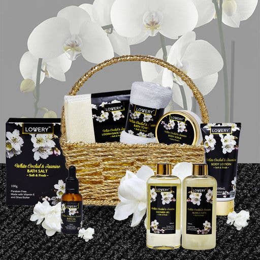 Lowery brand beauty products including bath salts, oils, and lotions with white orchids on a dark surface.