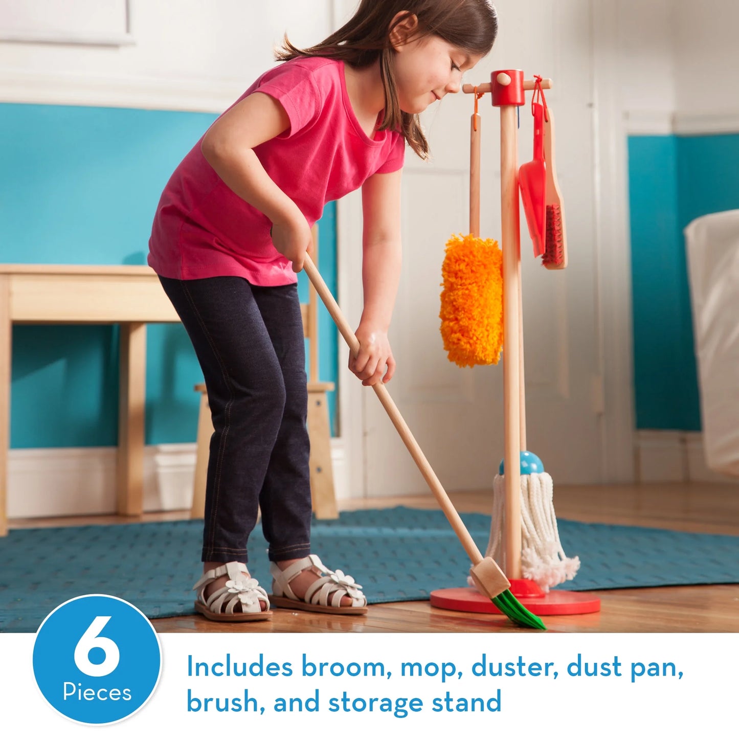 Child using a toy cleaning set with a broom, mop, duster, dust pan, brush, and storage stand in a room.