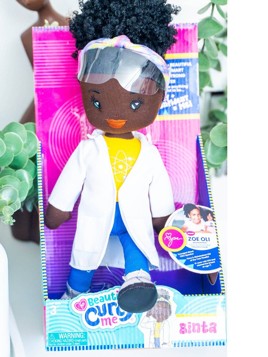 Toy doll with a white coat and colorful packaging on a white background